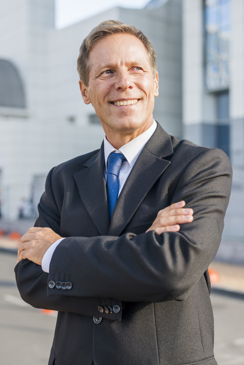 Supervisor de TI com braços cruzando e sorrindo